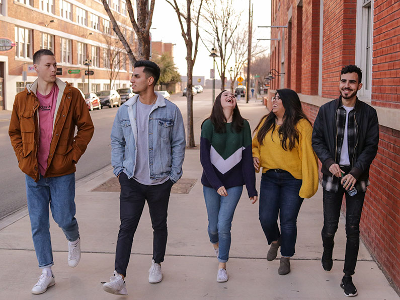 Five high school age people walking