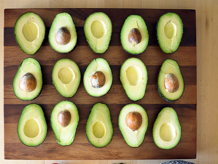 avocados cut in half in rows