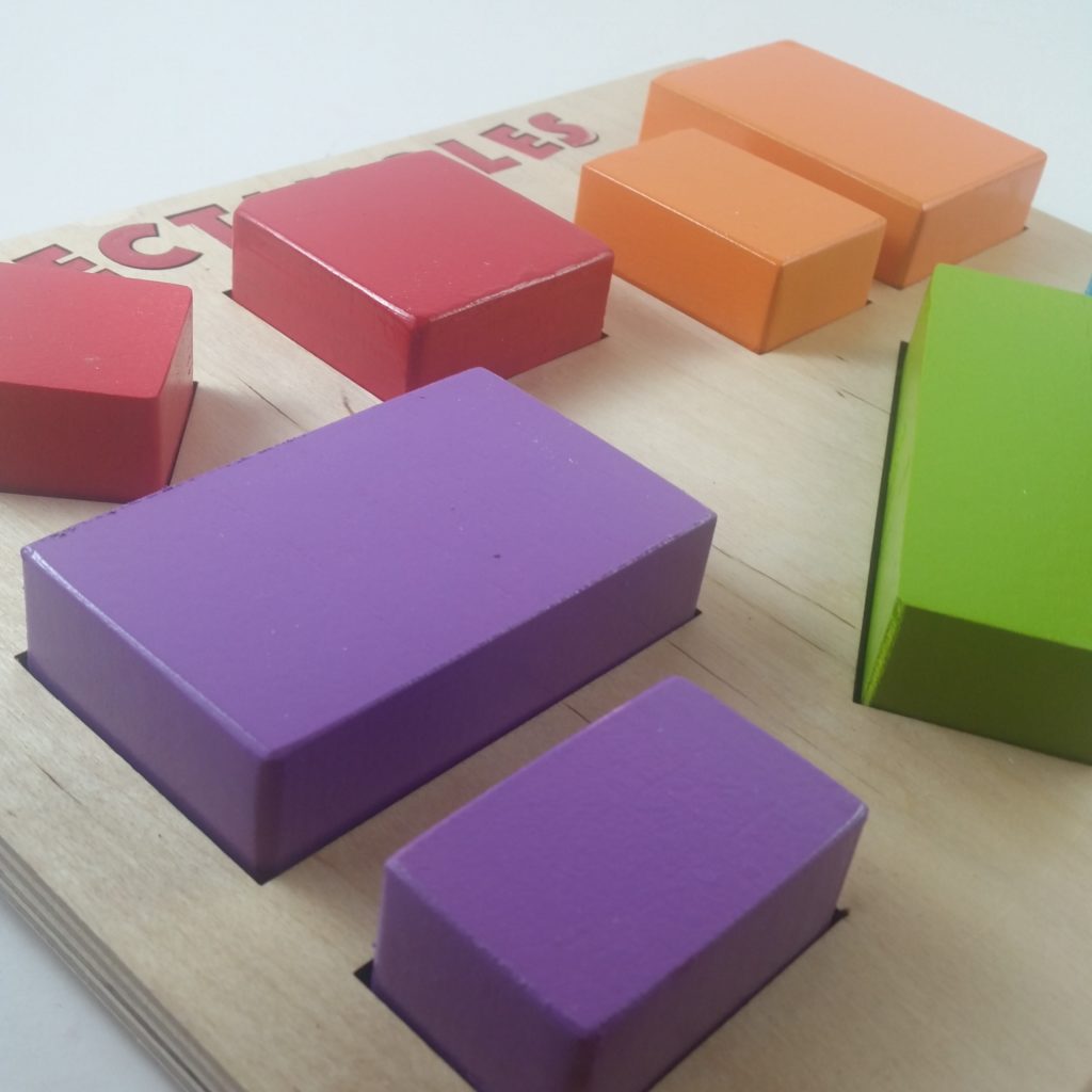 A colorful wooden puzzle for young children that says "Rectangles" at the top and has a diverse collection of rectangles (including two squares; one oriented on its vertex). 