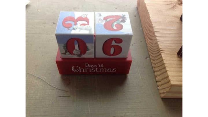 A countdown to Christmas calendar that has two cubes with numbers. They are currently oriented to read "06" days 'til Christmas. On the tops of the cubes, you can see an upside down 2 and a sideways 3