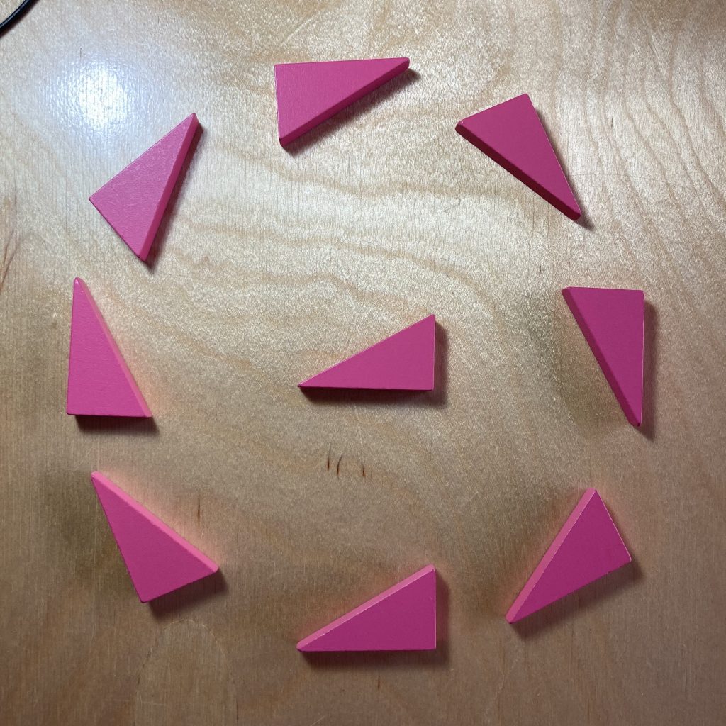 A single pink right triangle is surrounded by eight regularly spaced identical triangles in a circle, each pointing clockwise around the circle.