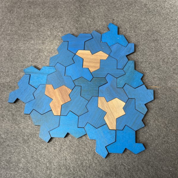 A tiling of hat tiles that uses mostly blue, plus three mirror-imaged, brown tiles.