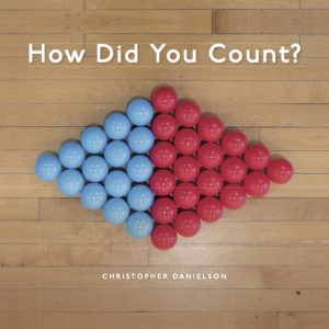 Brightly colored red and blue spheres carefully arranged in a diamond on a wood floor background. "How Did You Count?" is at the top of the image. "Christopher Danielson" is at the bottom.