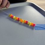 A developing bracelet. Pink-orange-transparent yellow-solid yellow, then back to pink as the pattern repeats.